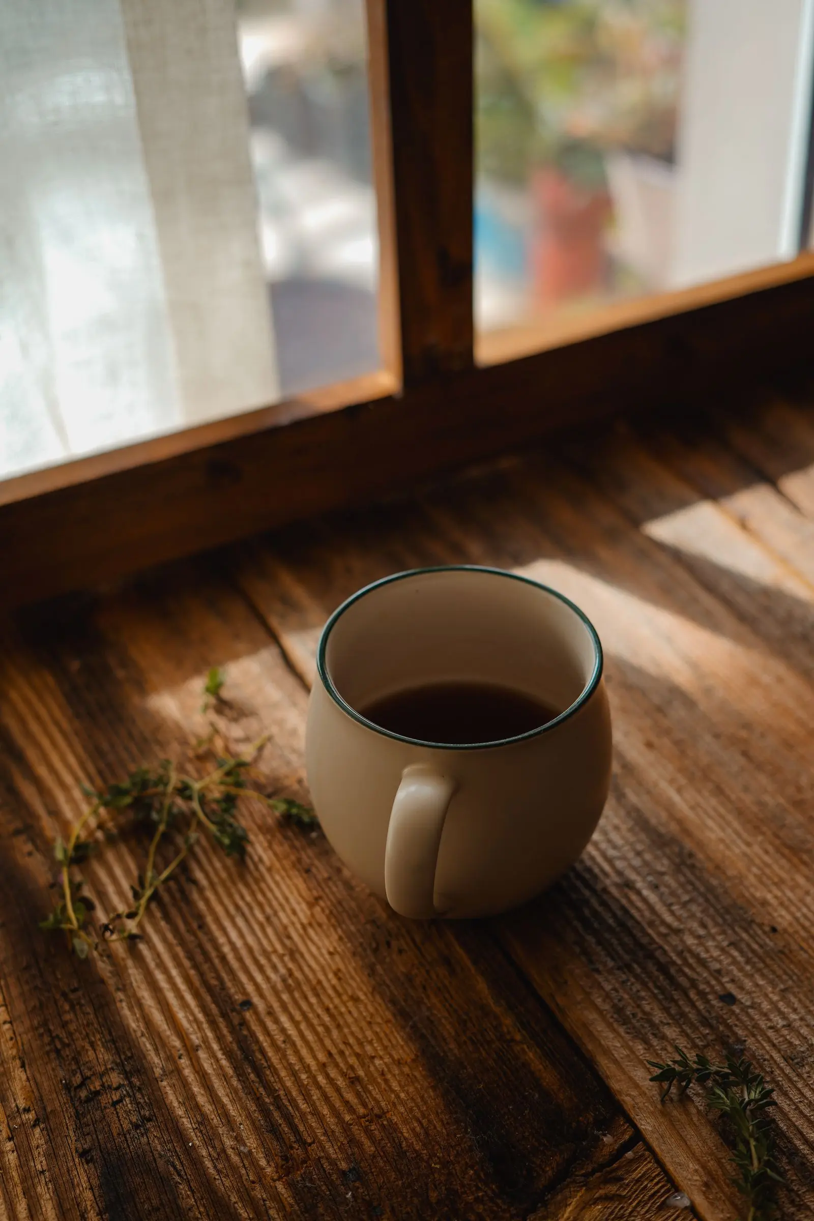 Warmes Morgenlicht fällt auf eine Tasse am Fenster